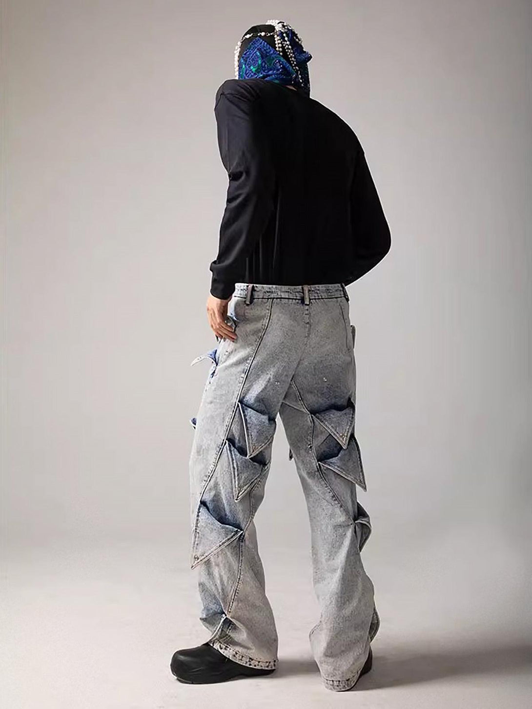 Model wearing TALISHKO deconstructed jeans, highlighting geometric design and urban fashion.