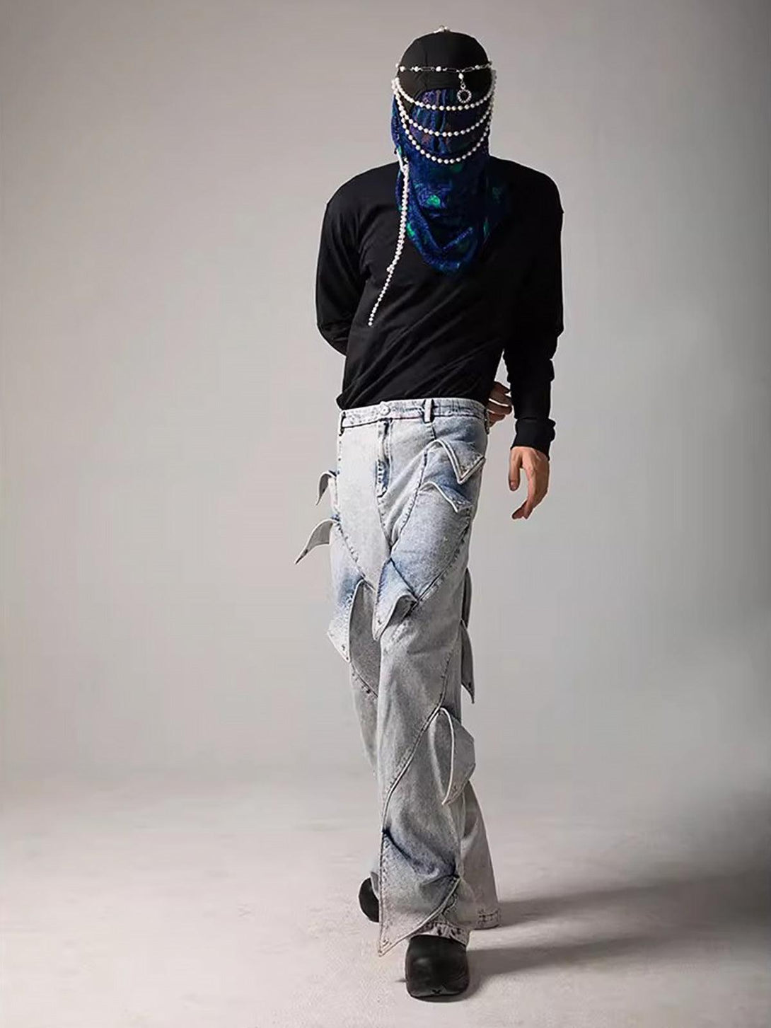Model in TALISHKO deconstructed jeans and black top, featuring bold avant-garde design.