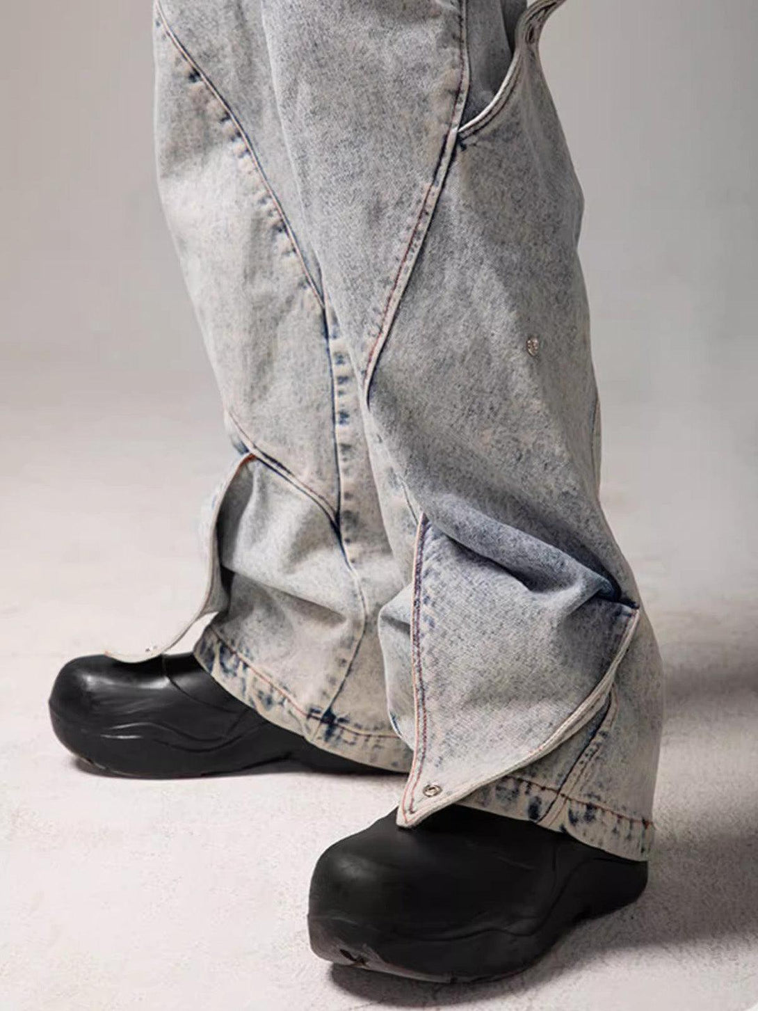 TALISHKO's deconstructed jeans feature unique geometric detailing over black shoes.