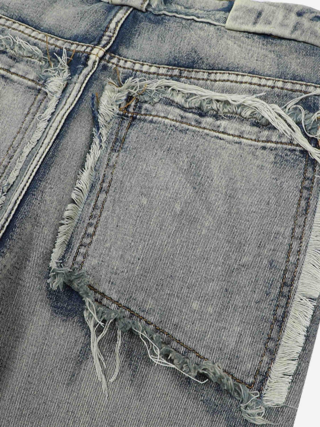 Intricate look at back pocket fraying on distressed jeans by TALISHKO, showcasing raw edges.