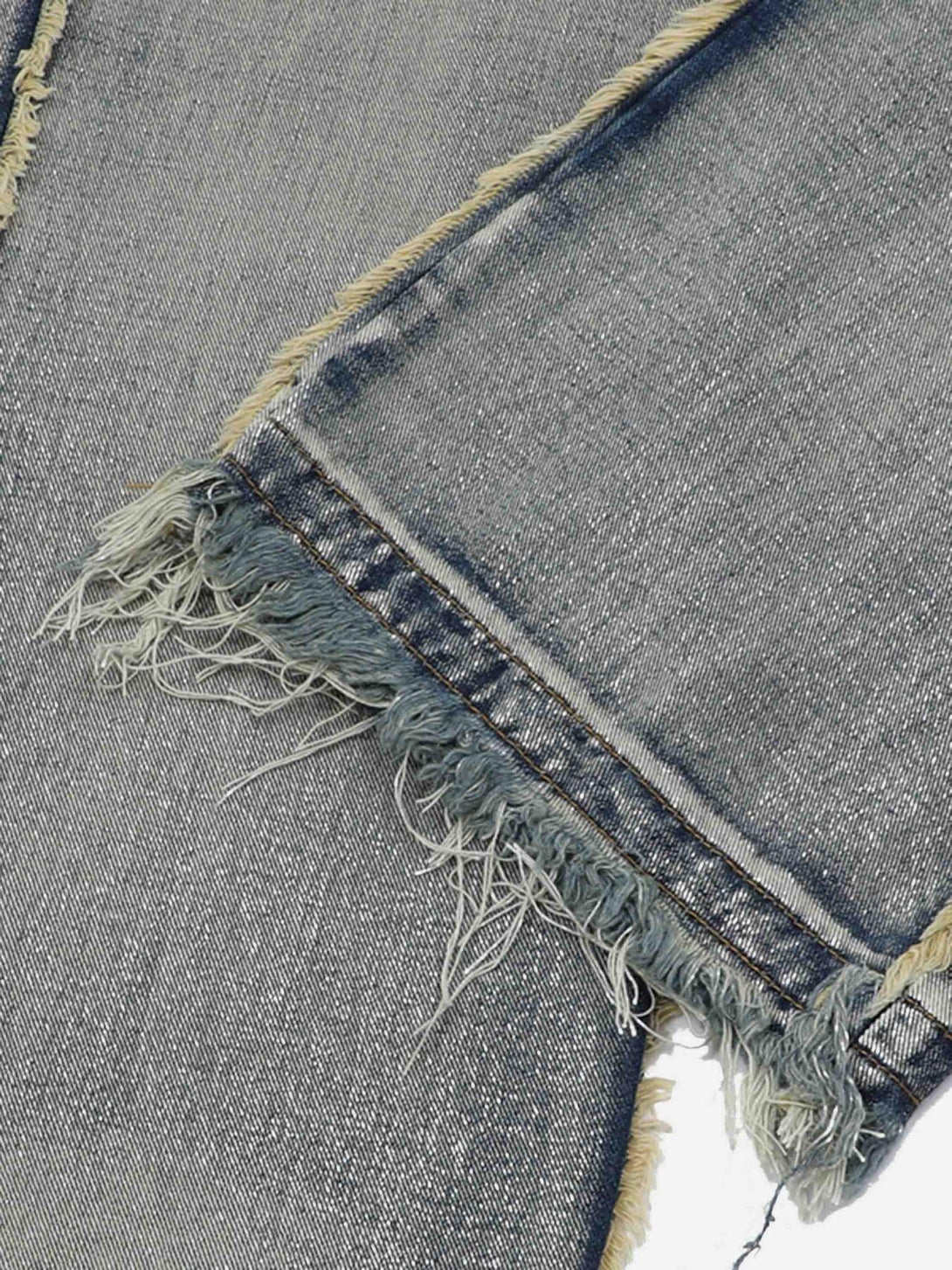 Intricate look at the distressed raw edges and frayed hems of jeans by TALISHKO.