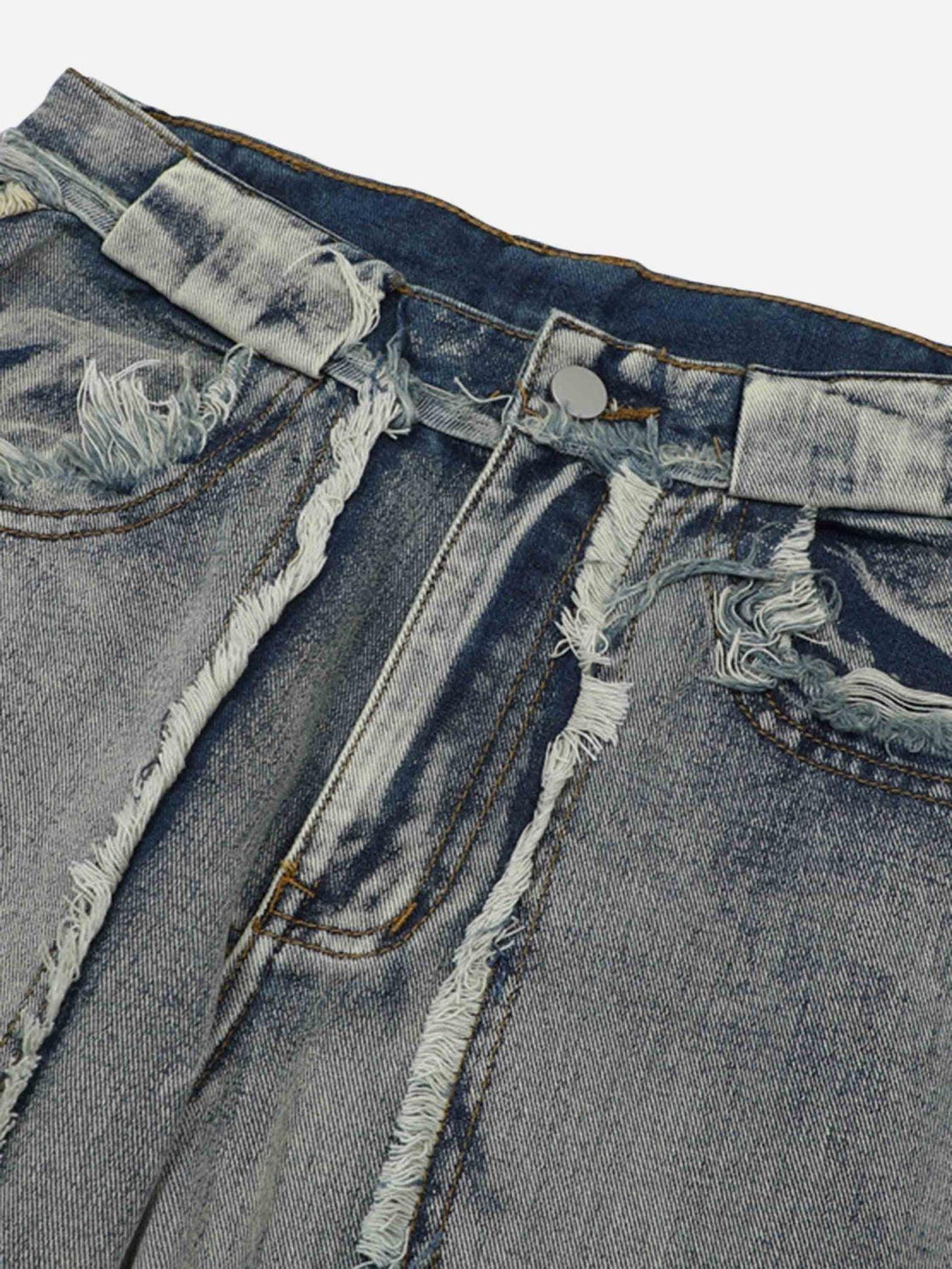 A close-up of distressed raw edge jeans by TALISHKO, highlighting the frayed waistband detail.
