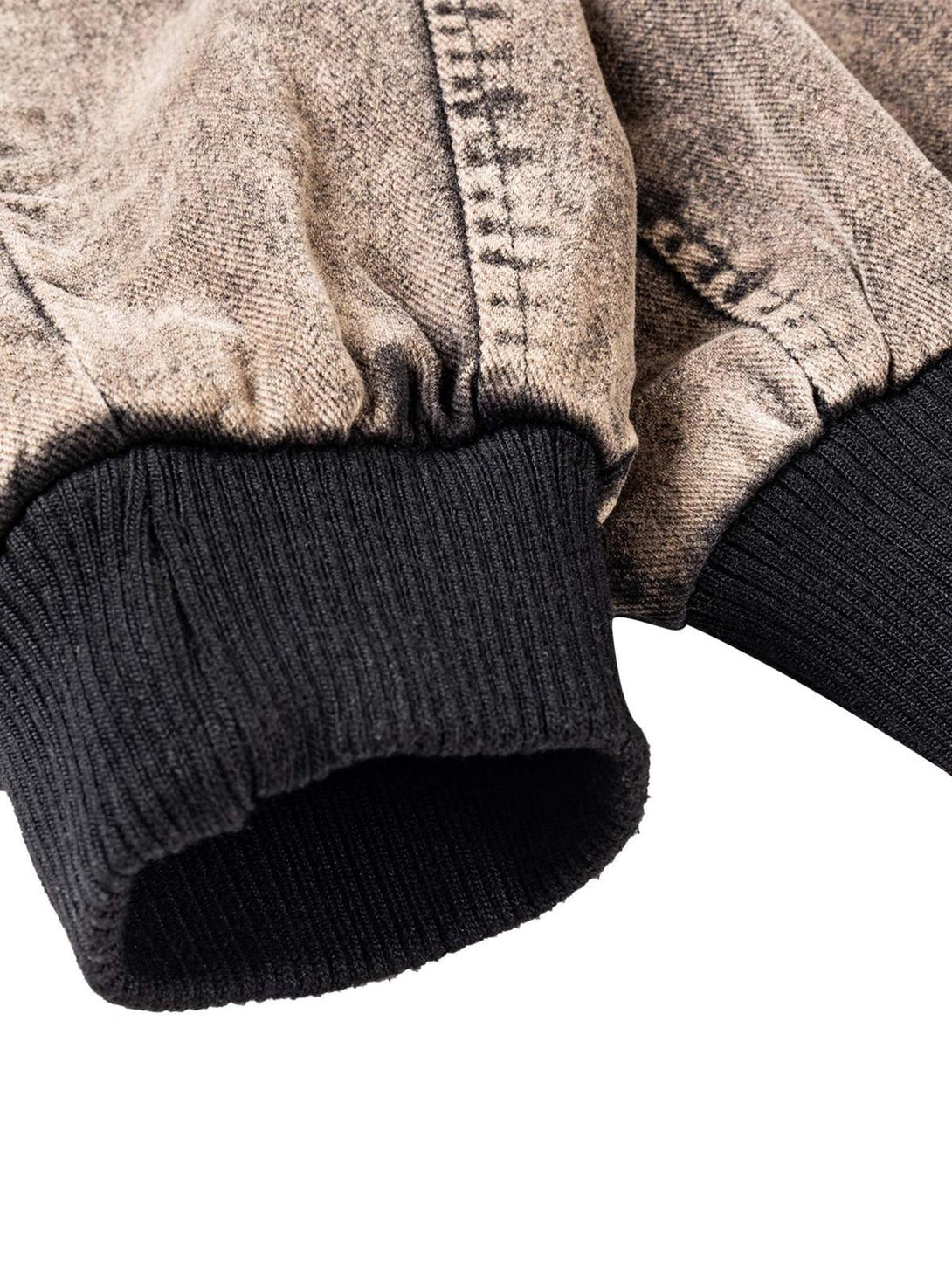 Intricate look at TALISHKO's distressed work jacket cuff, highlighting the ribbed knit detail.