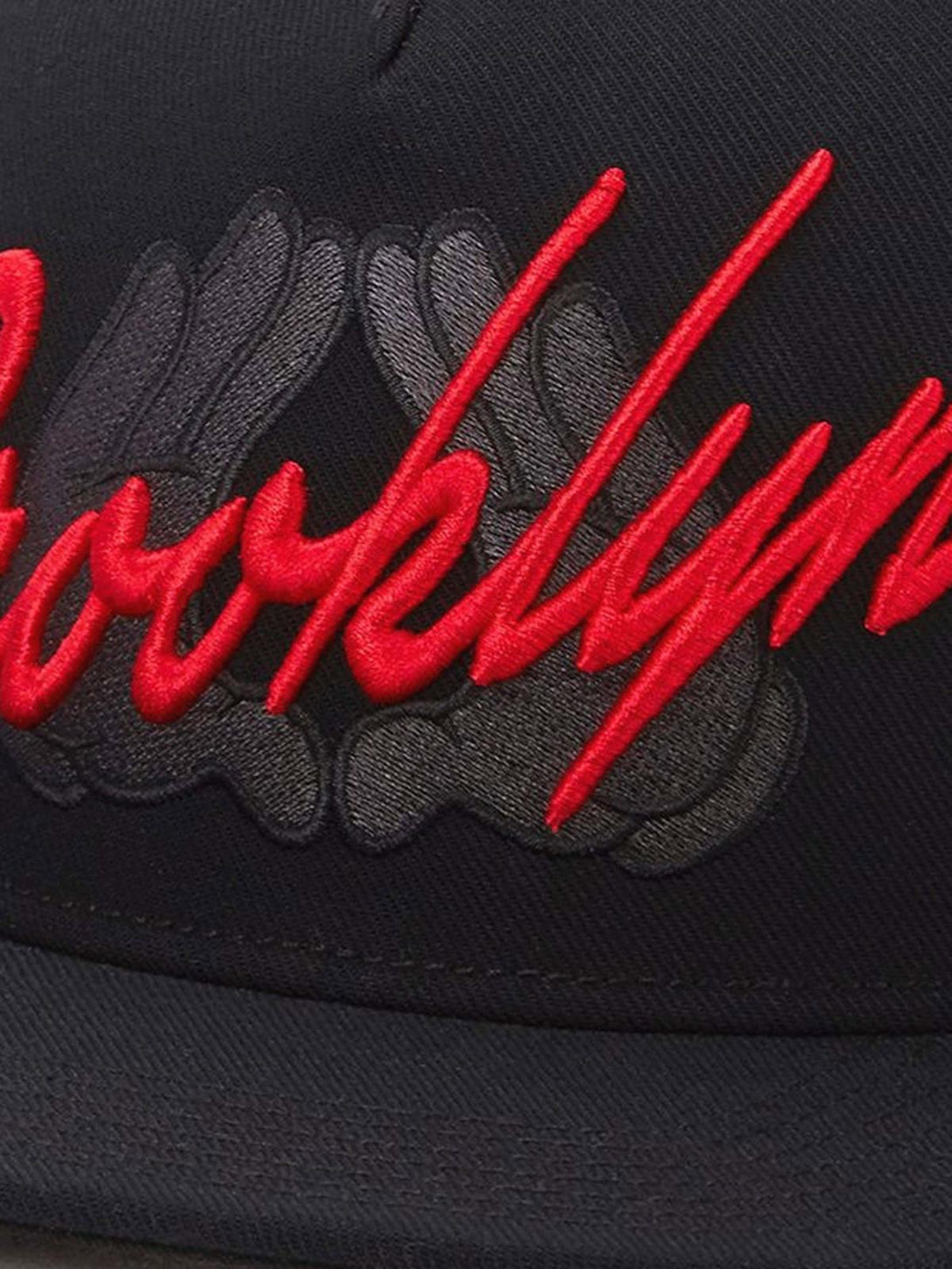 Zoomed-in detail of TALISHKO baseball cap with bold red embroidery, highlighting urban flair.