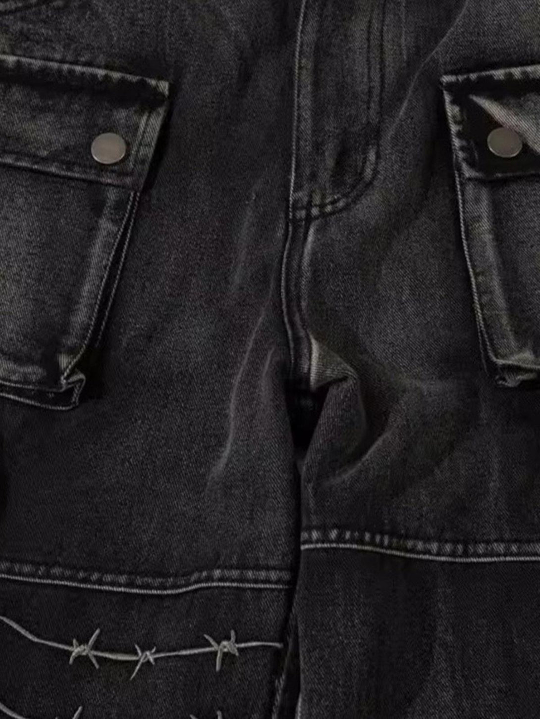 Detailed look at TALISHKO hip-hop jeans with barbed wire embroidery and cargo pockets.