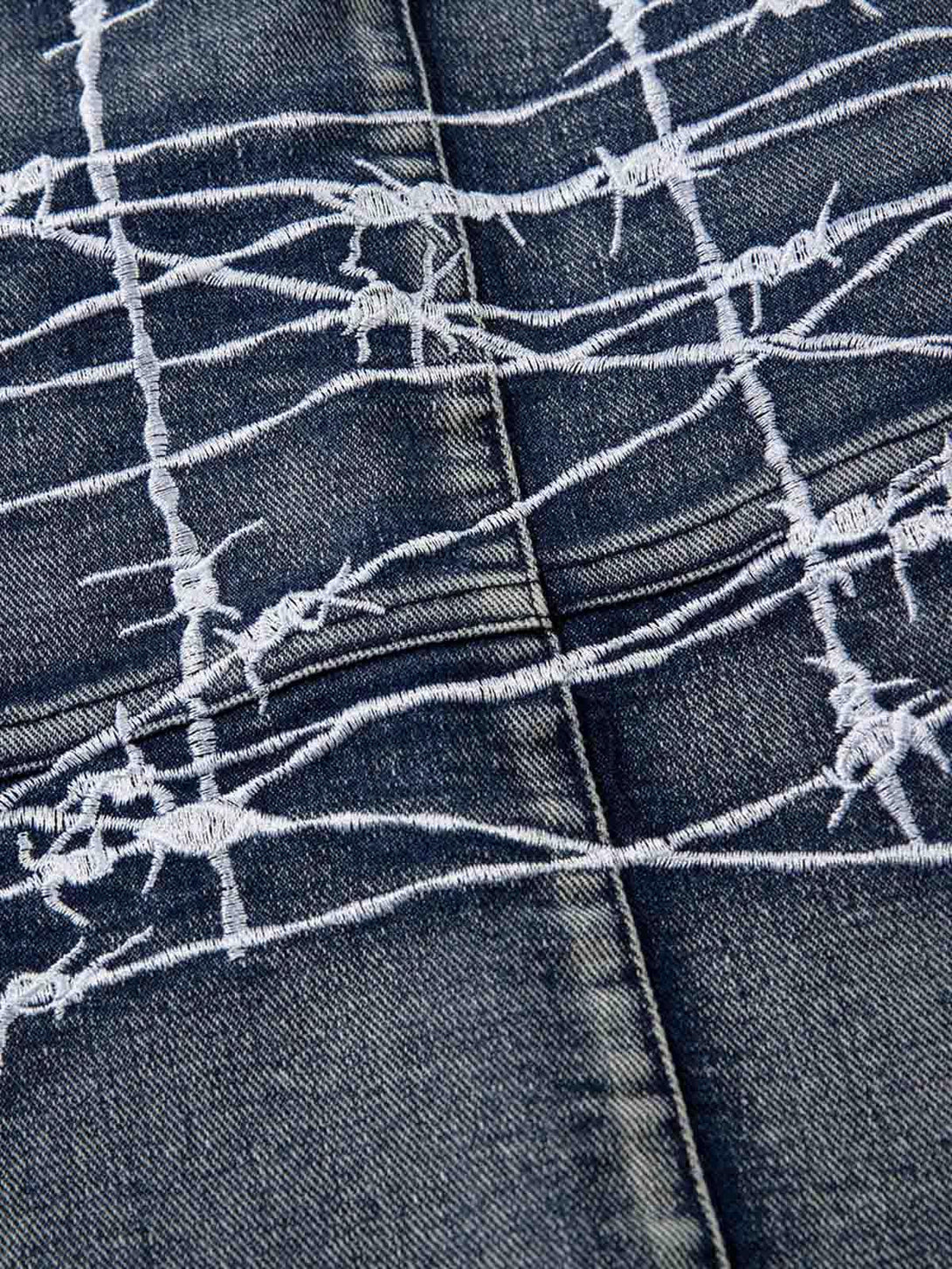 Intricate embroidery detail on TALISHKO hip-hop jeans, showcasing unique barbed wire design.