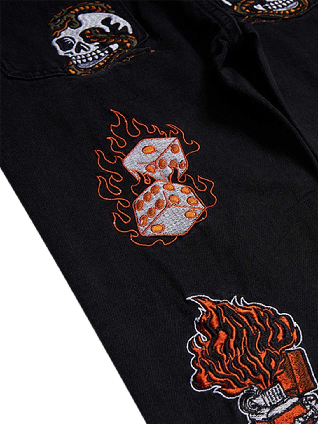 Intricate embroidery detail on TALISHKO retro jeans, featuring flame and skull motifs.