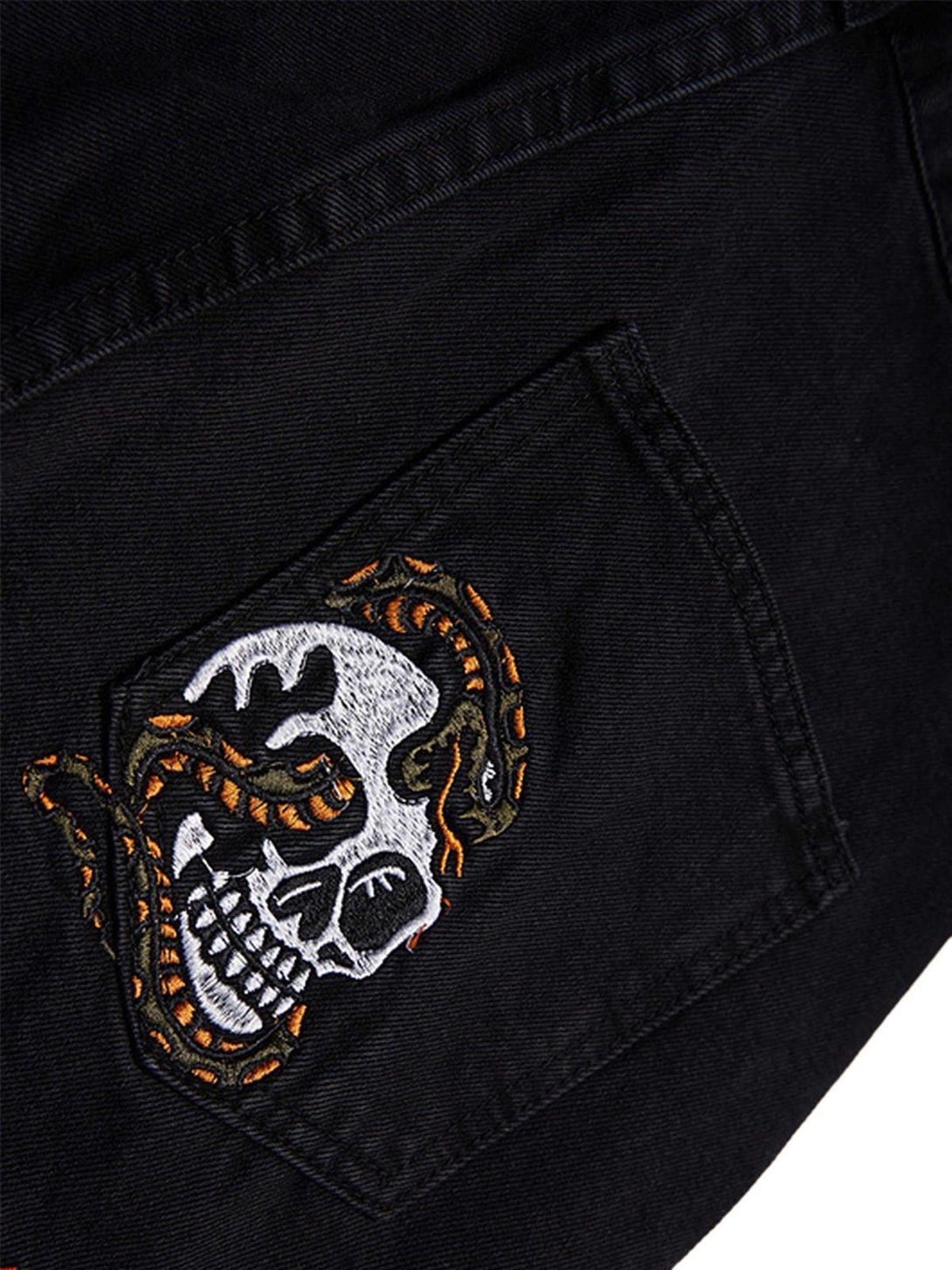 Intricate embroidery detail on TALISHKO retro jeans pocket, featuring skull and snake design.