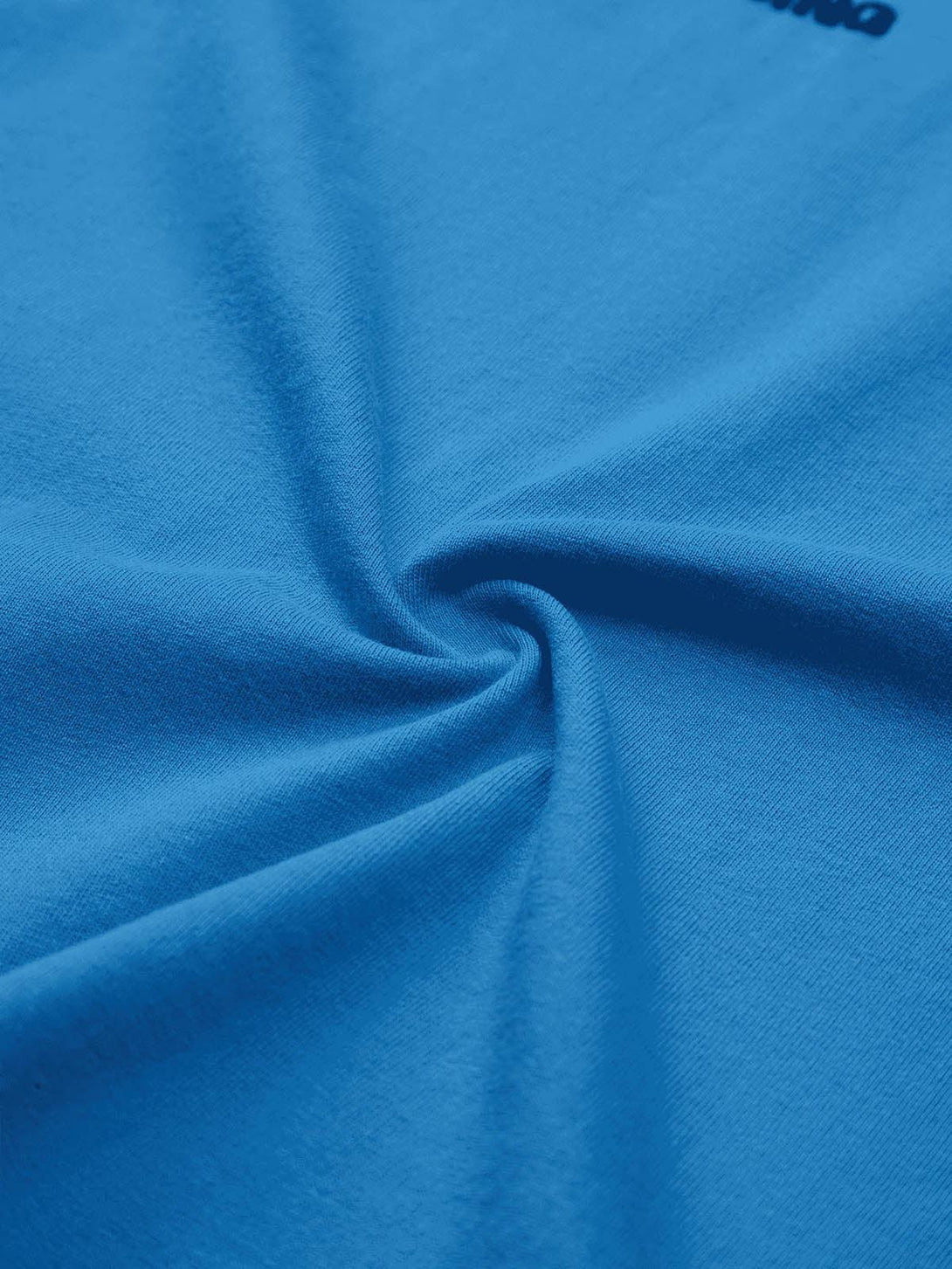A tight crop highlighting the blue fabric texture of a TALISHKO T-shirt, showcasing quality material.