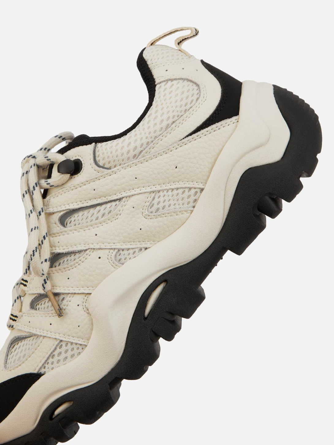 A detailed view of TALISHKO hiking shoes, showcasing textured beige and black material.