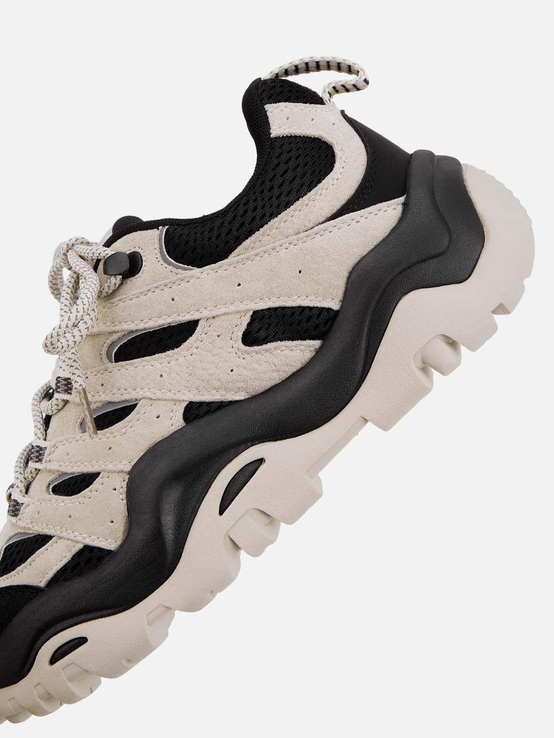 Intricate look at TALISHKO hiking sneakers, featuring beige suede and black mesh details.