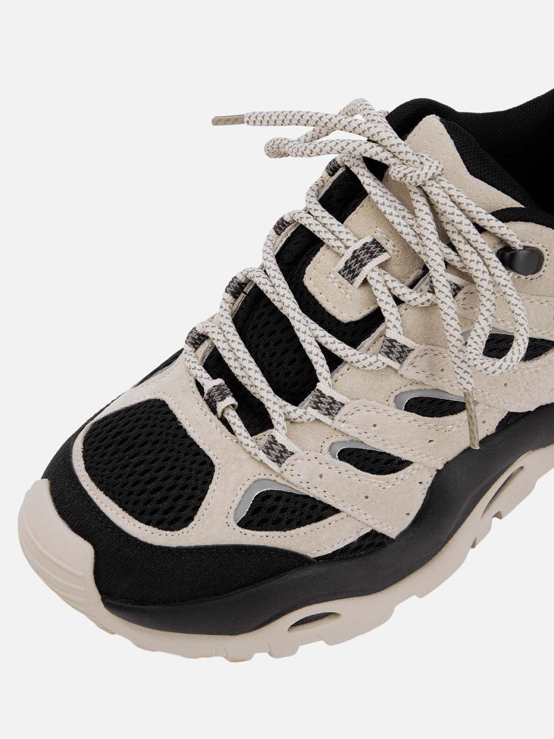 A close-up of TALISHKO hiking shoes, highlighting the intricate lacing and black mesh detail.