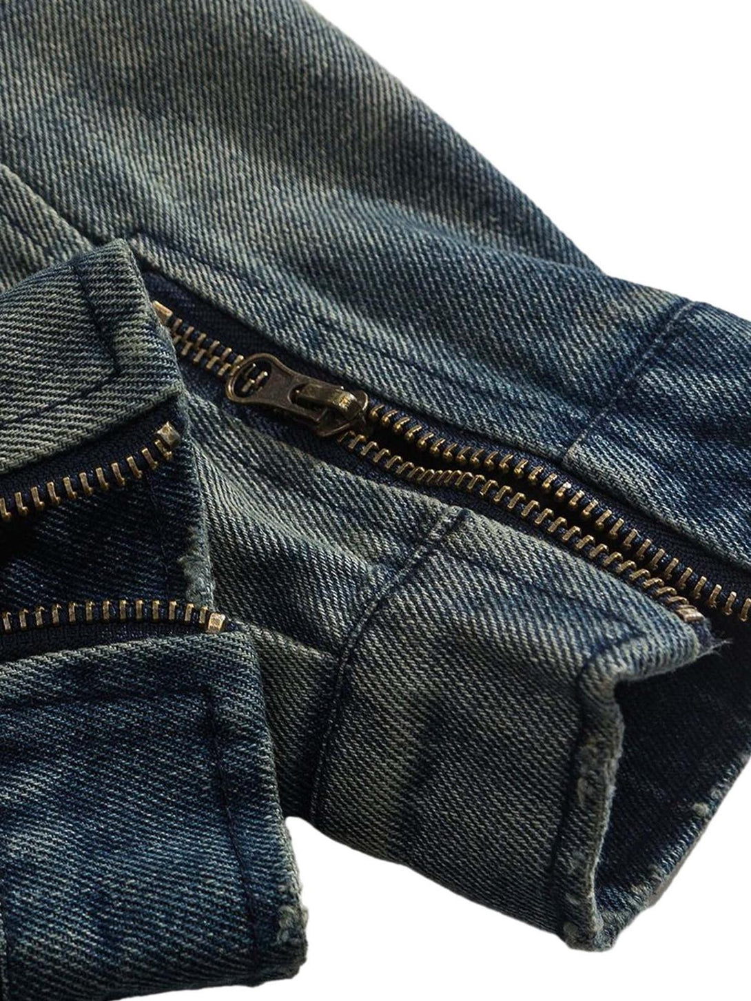 A detailed view of TALISHKO denim jacket's zipper and texture, showcasing rugged style.