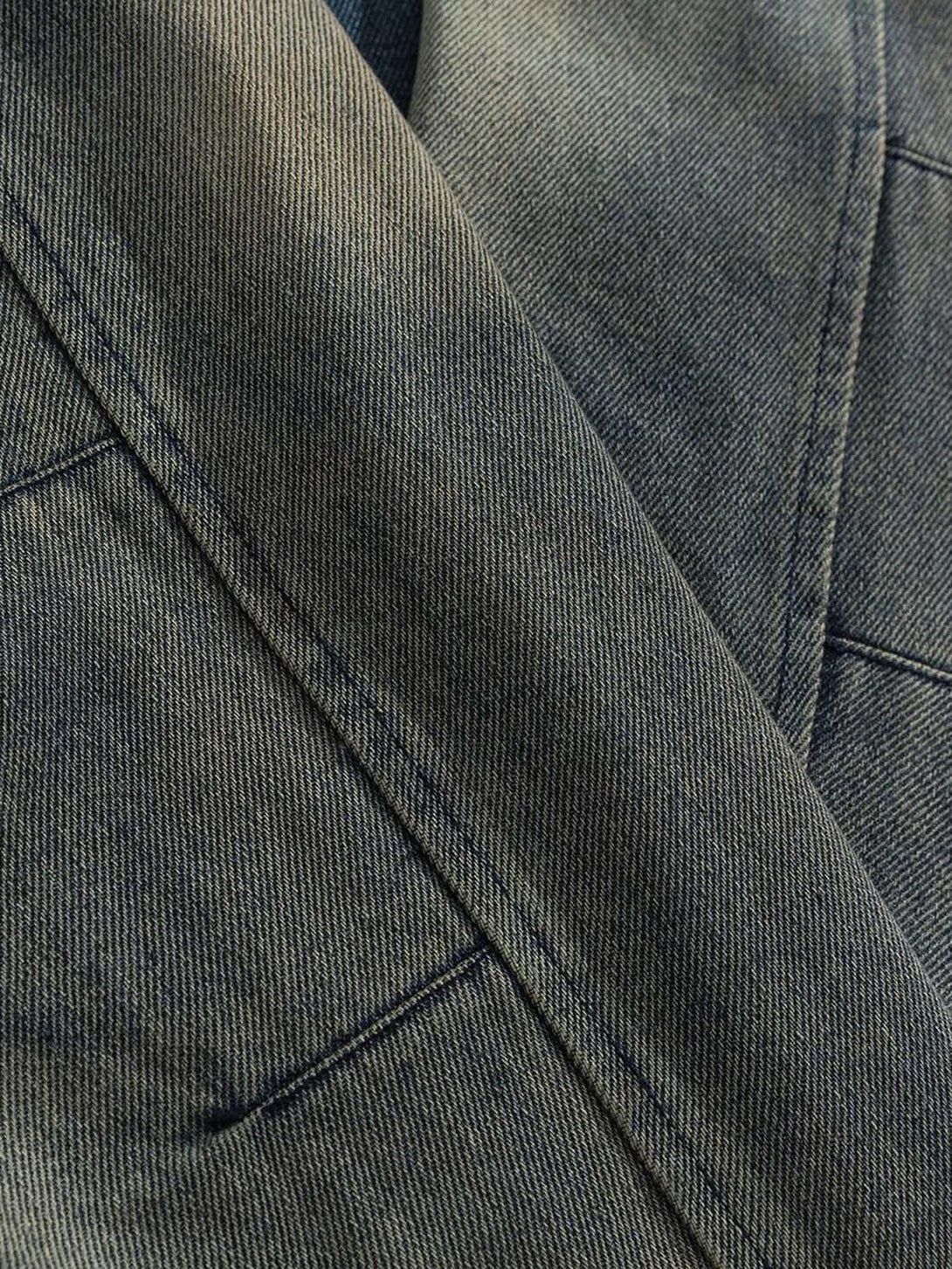 Detailed fabric and stitching of TALISHKO's distressed denim jacket, showcasing its unique texture.