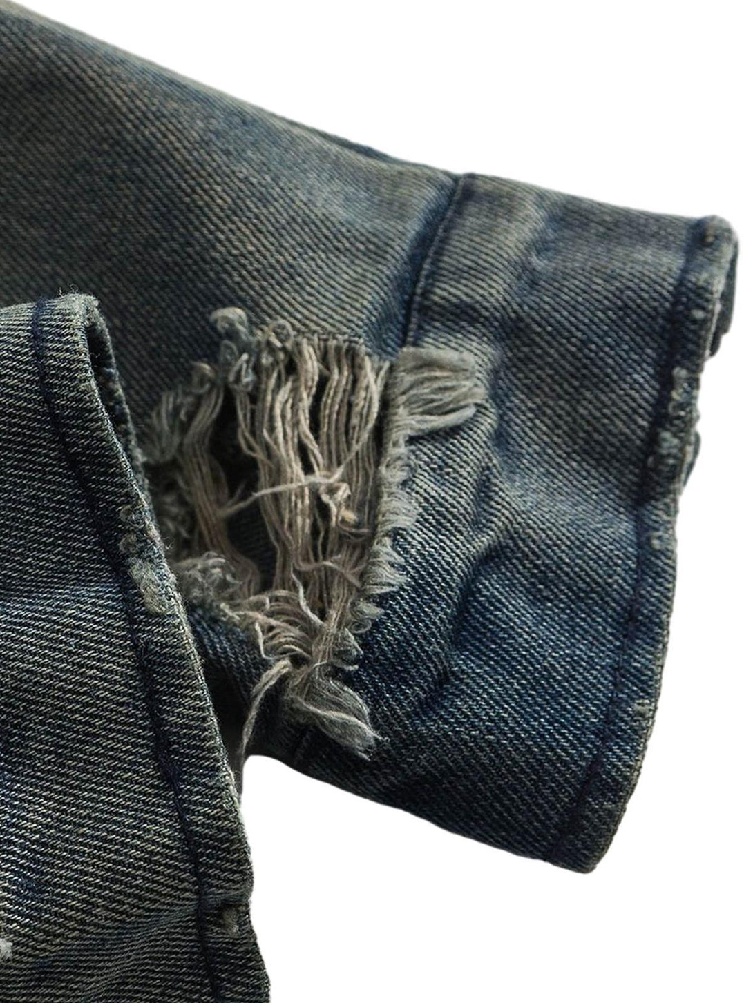 Focusing on the rugged hem detail of the TALISHKO distressed denim jacket, highlighting its edgy style.