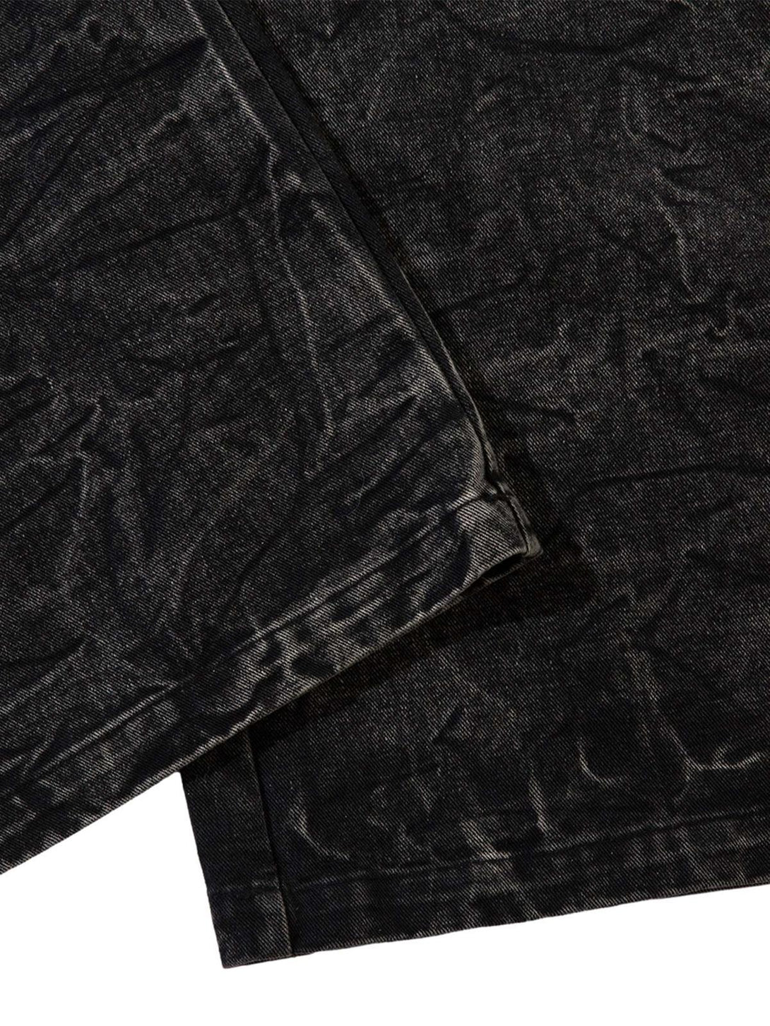 A close-up of TALISHKO distressed jeans with a textured wash and intricate detailing.