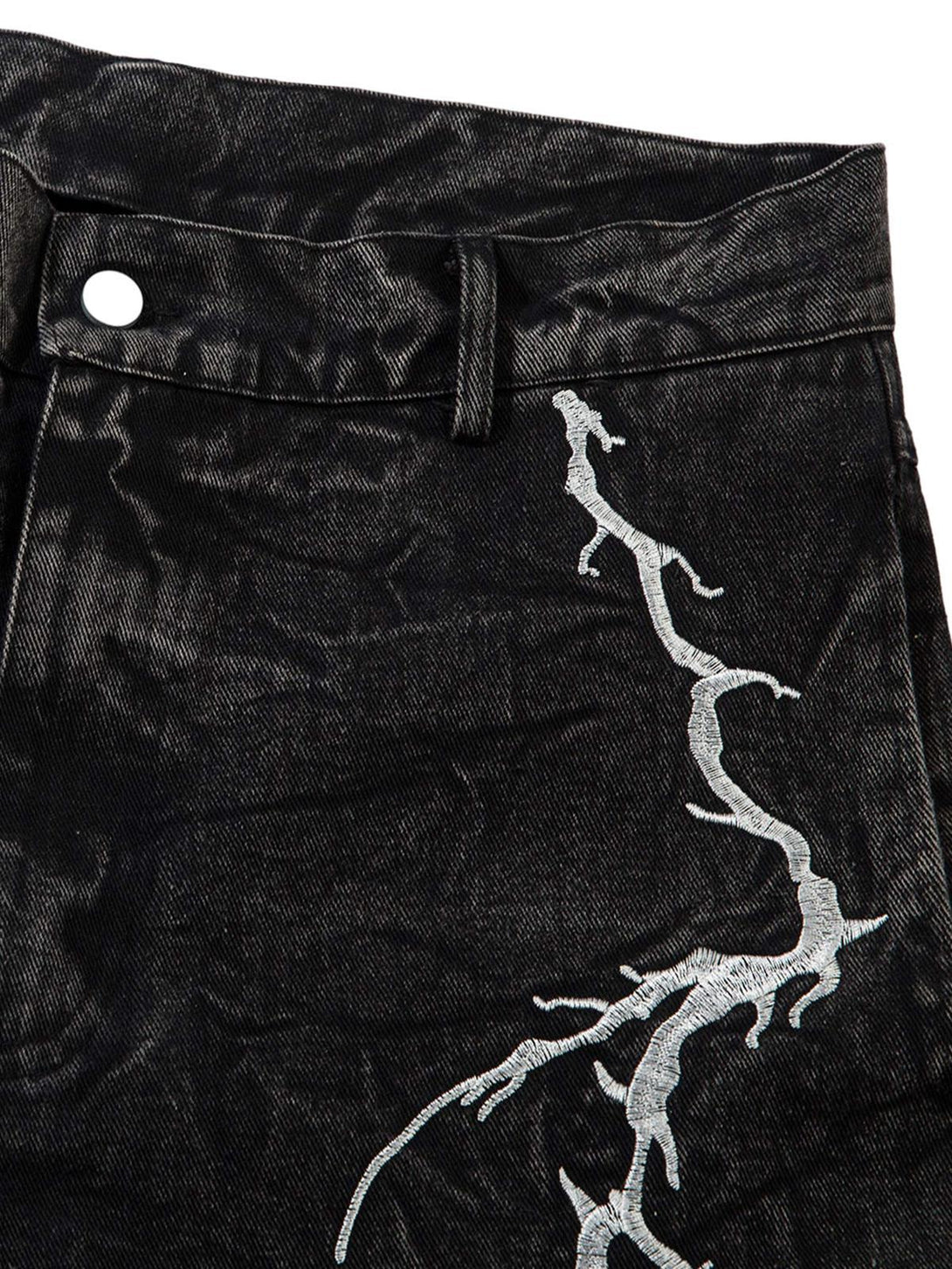 A close-up of TALISHKO hip-hop jeans, highlighting white lightning embroidery on a textured fabric.