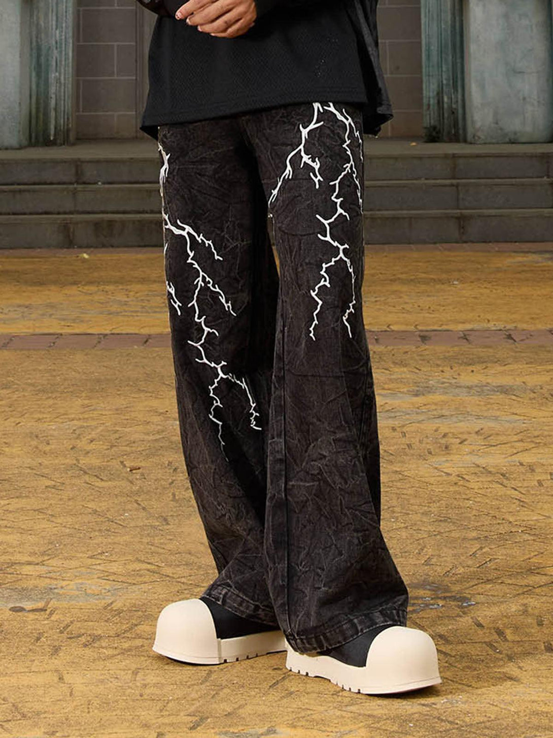 A detailed look at TALISHKO distressed hip-hop jeans with striking white lightning patterns.