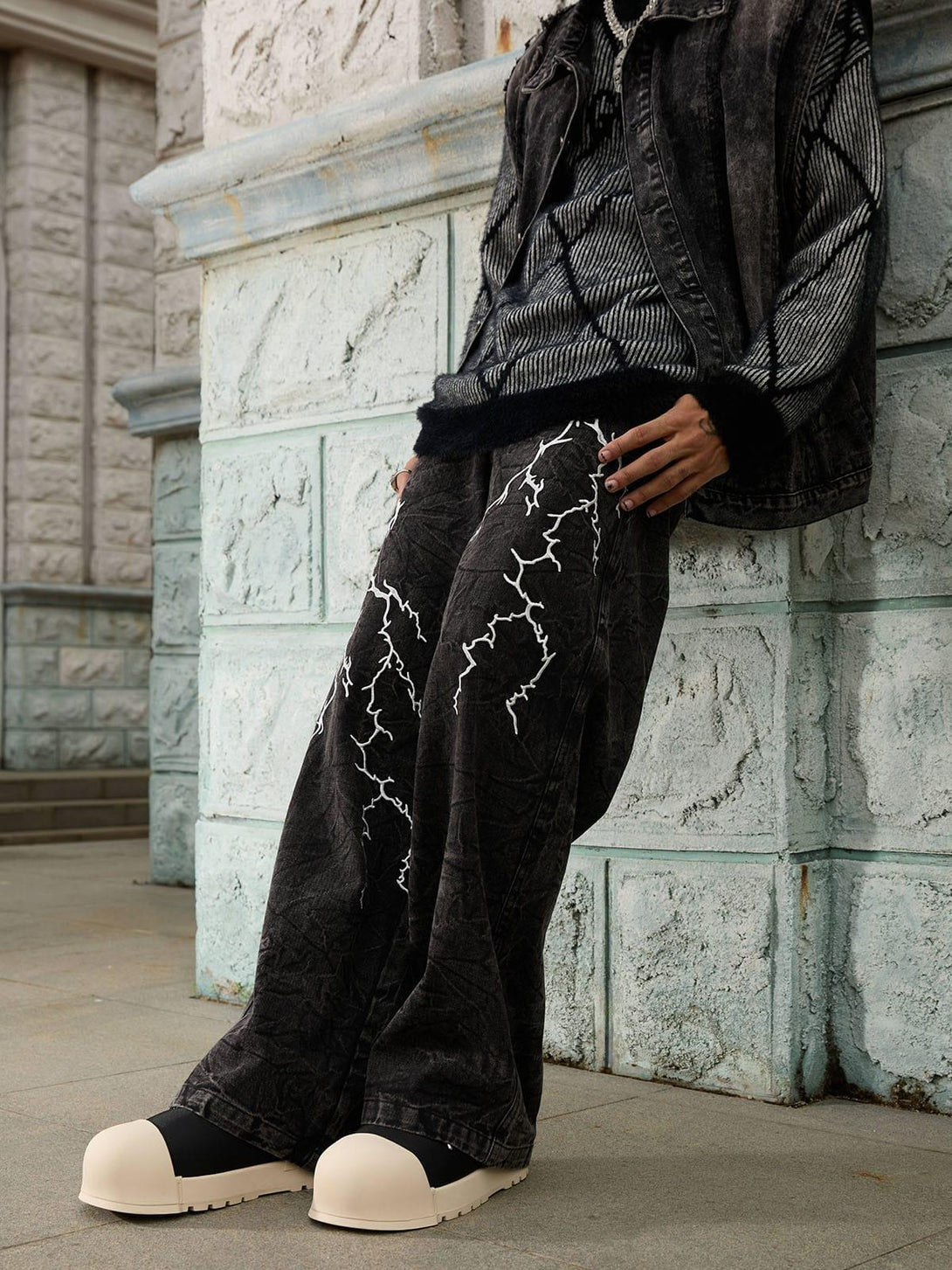 TALISHKO distressed hip-hop jeans with bold white lightning patterns, styled with casual flair.