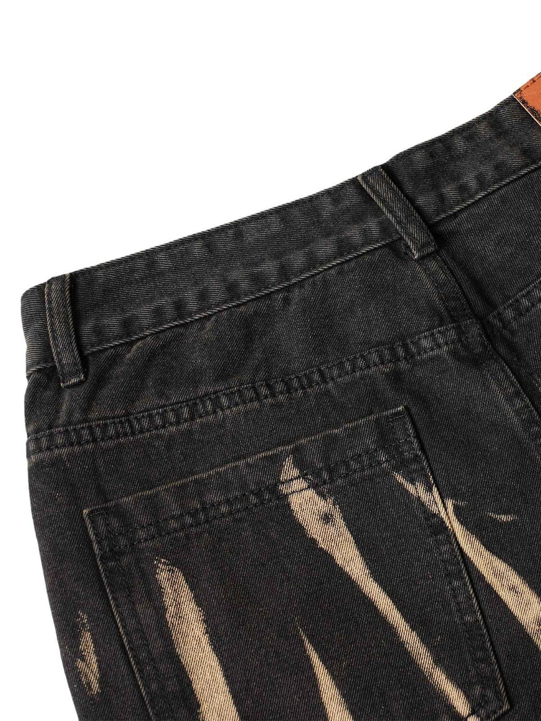 A detailed look at TALISHKO jeans' back pocket, highlighting hand-painted spray patterns.