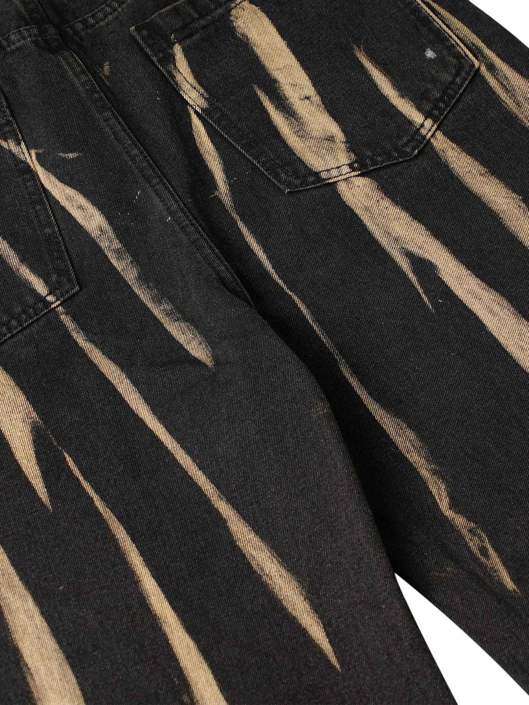 Zoomed-in texture of TALISHKO jeans showcasing hand-painted spray design for edgy street style.