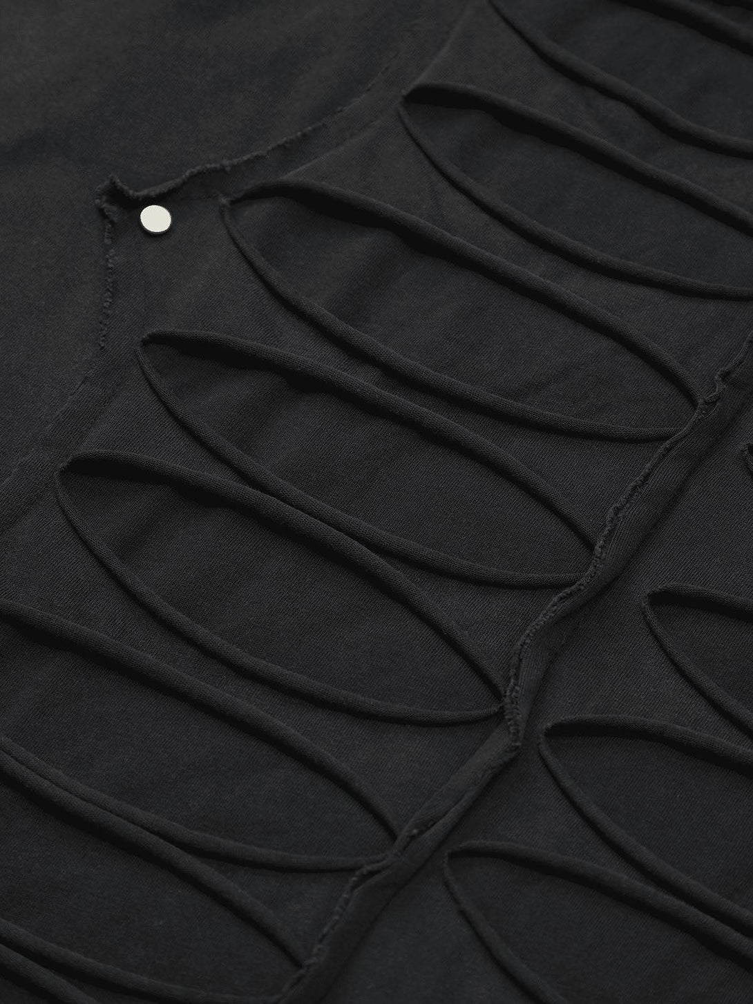 A tight crop highlighting TALISHKO's hole design T-shirt, showcasing a modern street style.