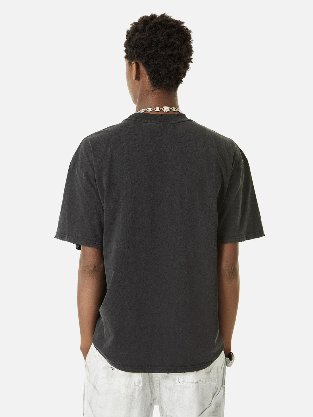 Back view of a black TALISHKO T-shirt with hole design, embodying a hip hop street style.