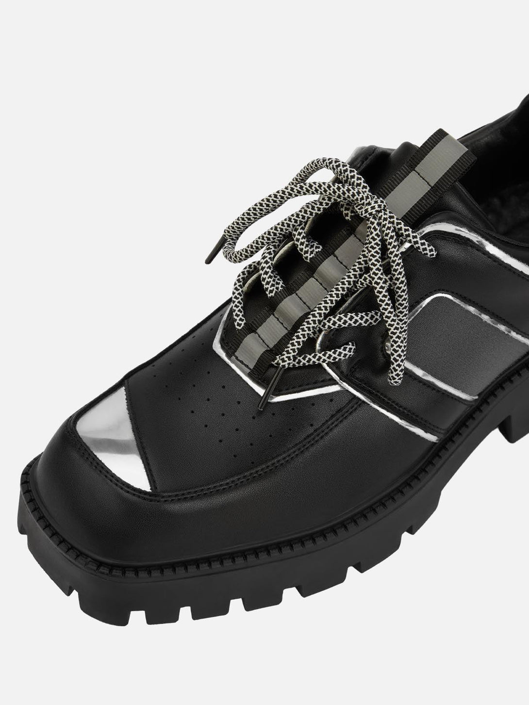 Close-up of TALISHKO black leather shoes featuring metal accents and unique lace details.