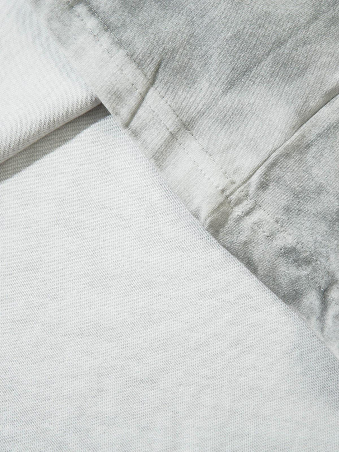 Detailed fabric and stitching of TALISHKO T-shirt showcasing patchwork texture and style.