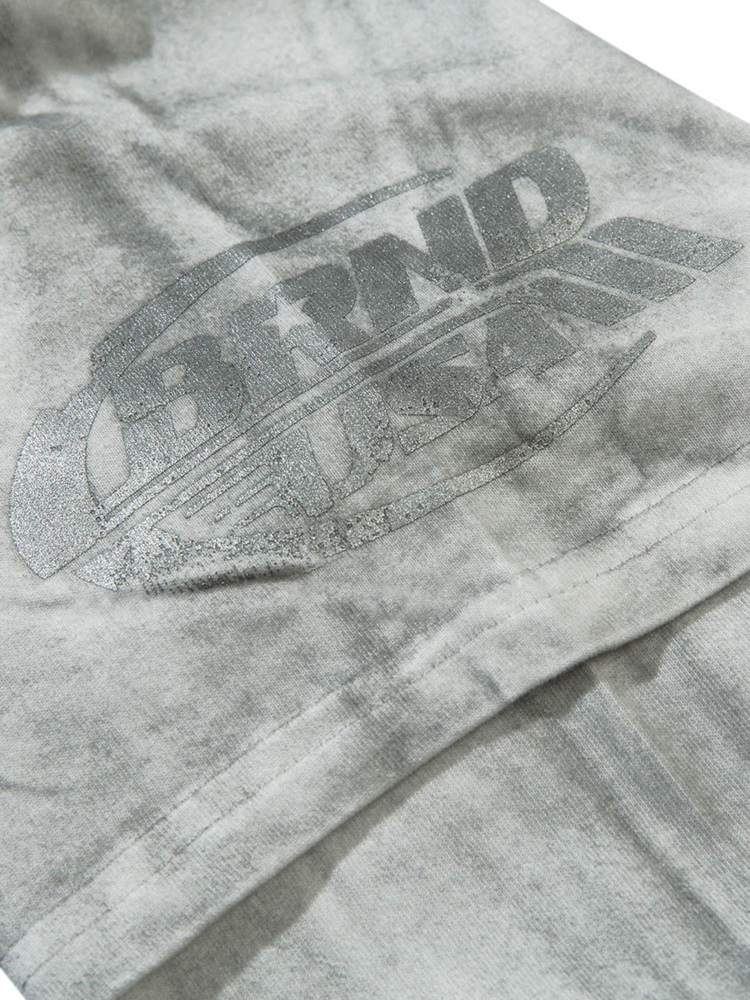 A detailed view of TALISHKO T-shirt highlighting subtle graphics and patchwork texture.