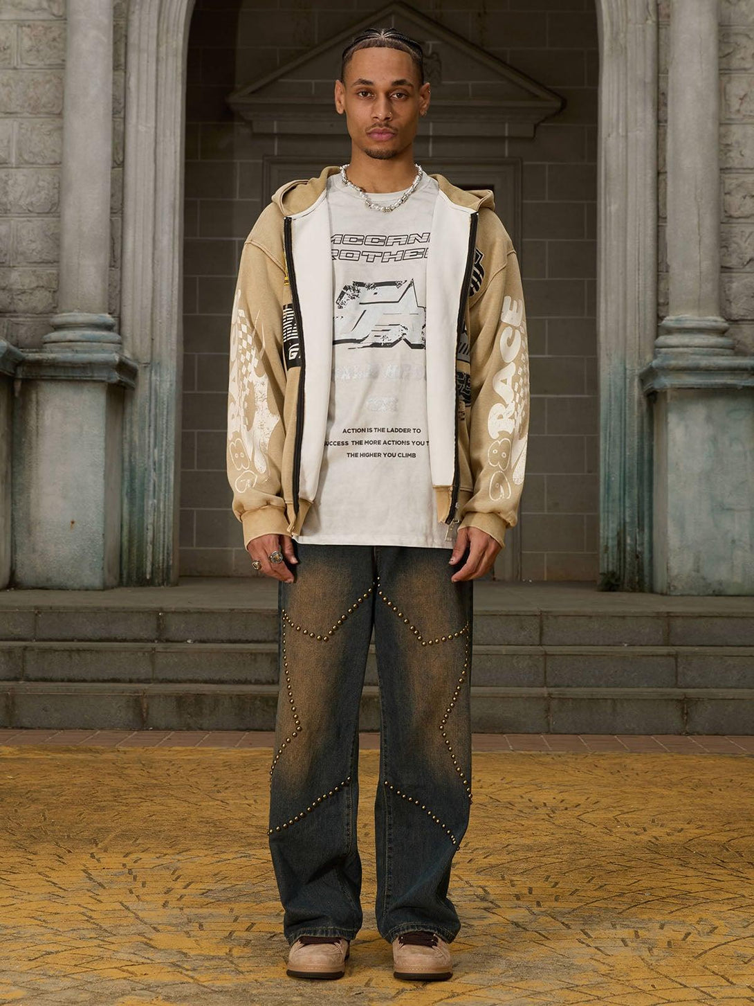 Model wearing TALISHKO hip-hop patchwork T-shirt and jeans with stud detailing.