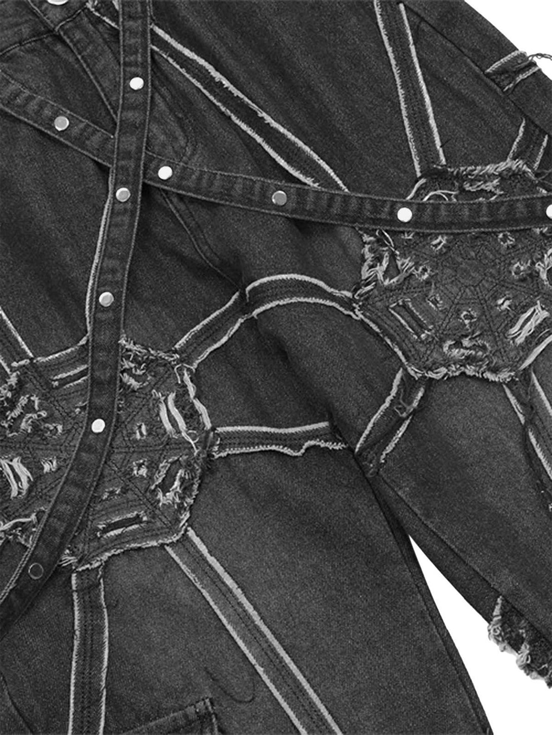 Intricate design detail of TALISHKO denim pants showcasing spider web patterns and textures.