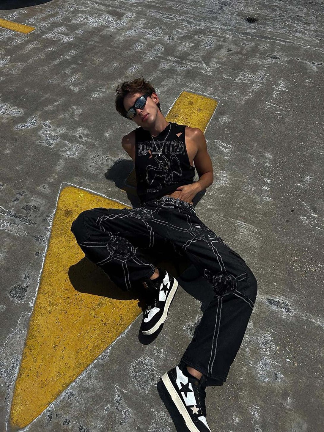 Model wearing TALISHKO high street hip-hop denim pants with spider web design, exuding urban flair.