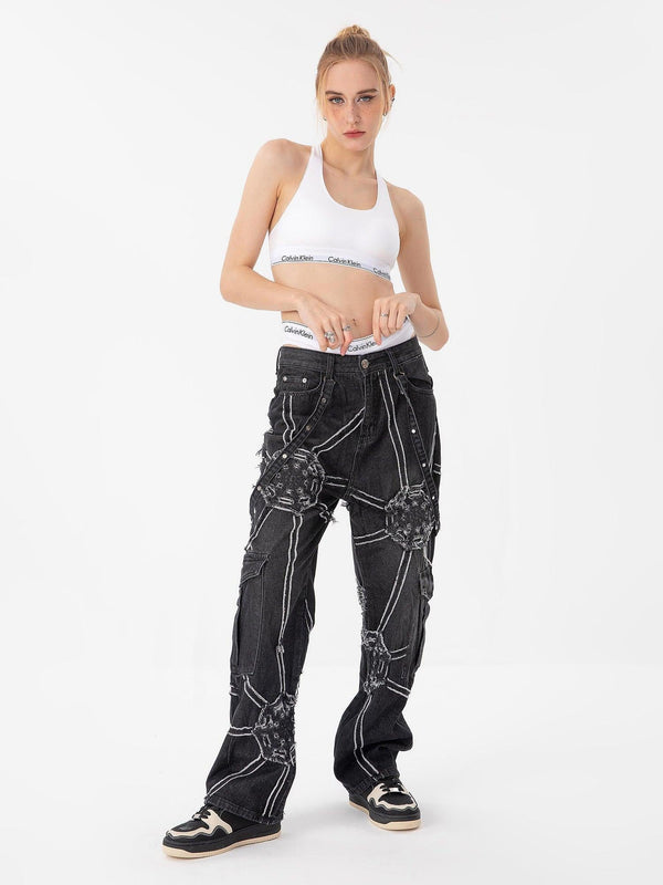 Model showcasing TALISHKO high street hip-hop spider web denim pants with unique stitching details.