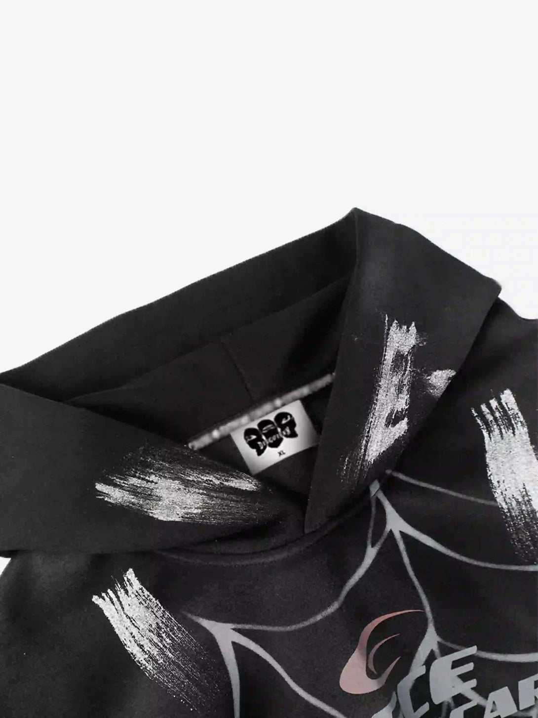TALISHKO hoodie detail featuring bold brushstrokes and spider web design, highlighting urban flair.