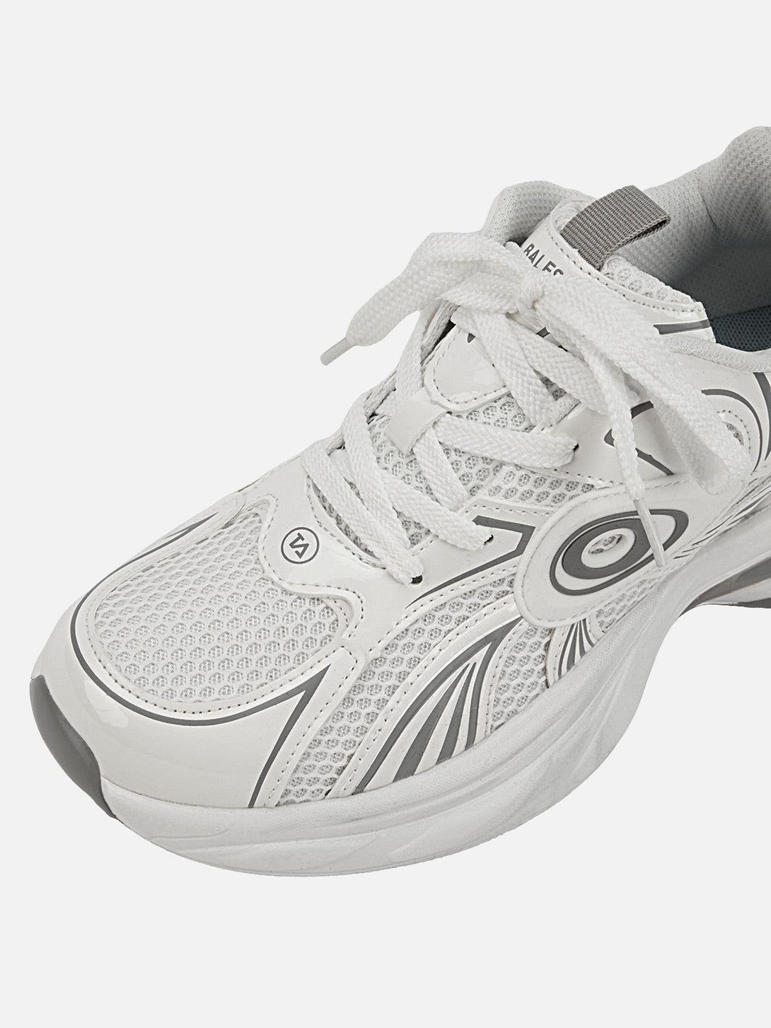 Close-up of white TALISHKO sneakers highlighting sleek design and dynamic patterns.