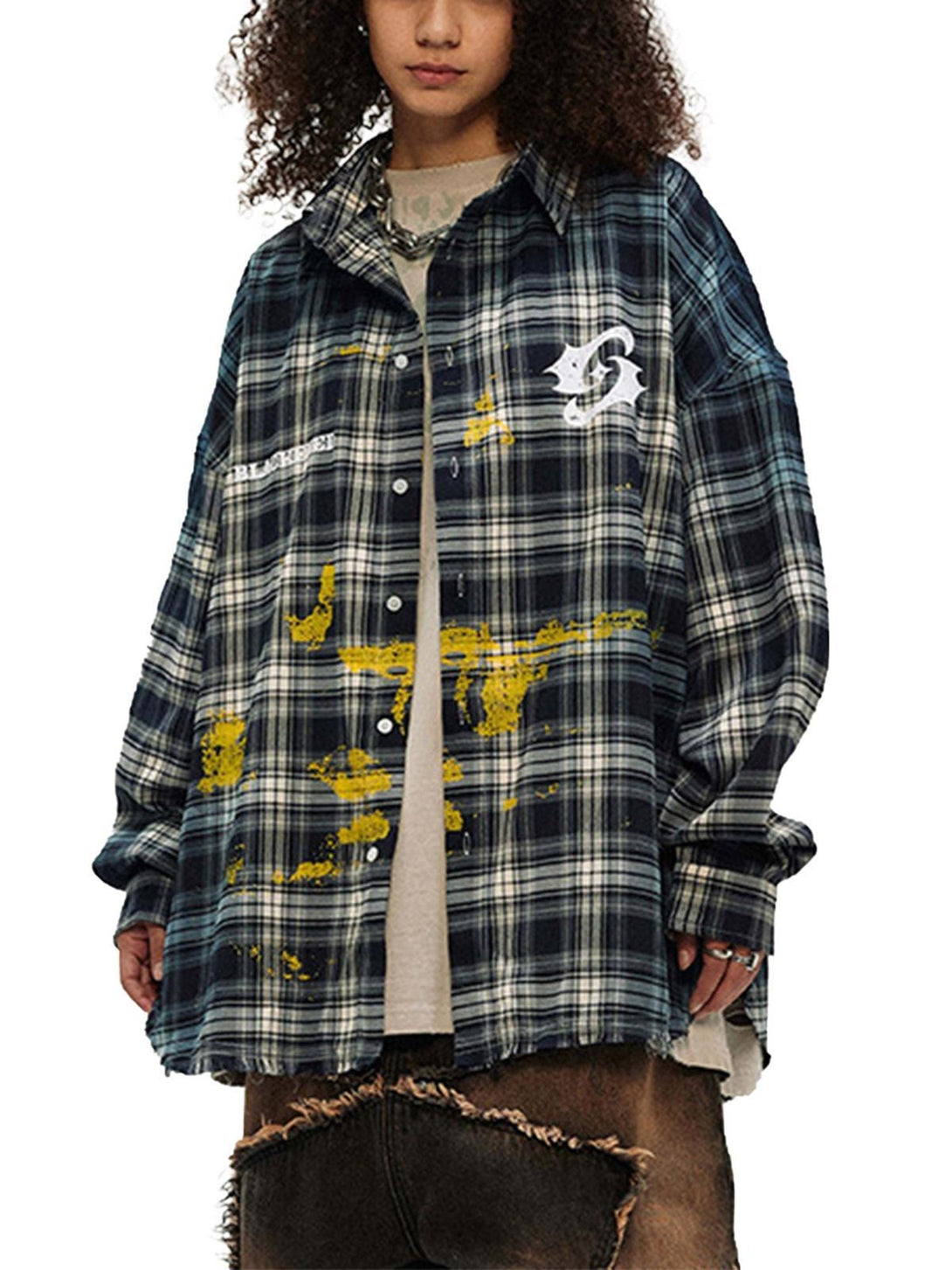 Model wearing a plaid shirt with yellow spray print by TALISHKO, embracing hip hop style.