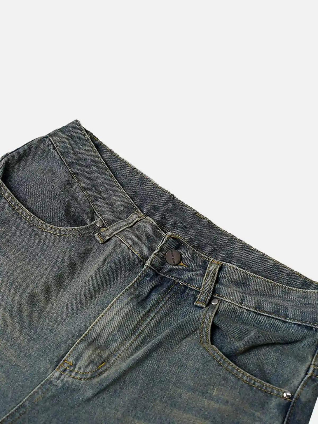 A detailed view of TALISHKO's washed distressed jeans, highlighting texture and stitching.