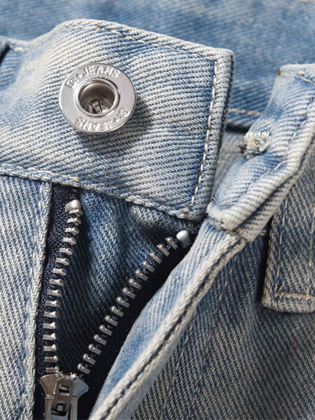 A tight crop highlighting TALISHKO jeans' zipper and button details in street style denim.