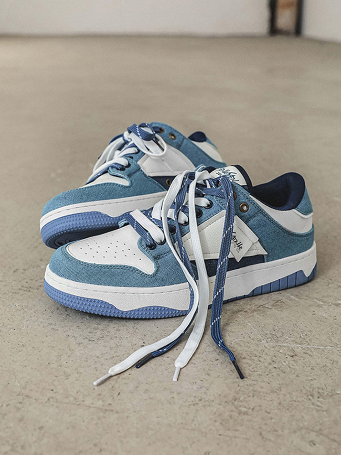 TALISHKO slip-on sneakers in blue and white, showcasing a stylish casual design on concrete.