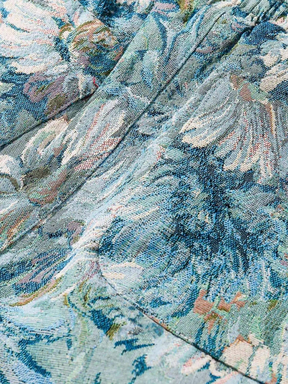 Zoomed-in texture of TALISHKO's jacquard embroidery shorts, highlighting intricate floral design.