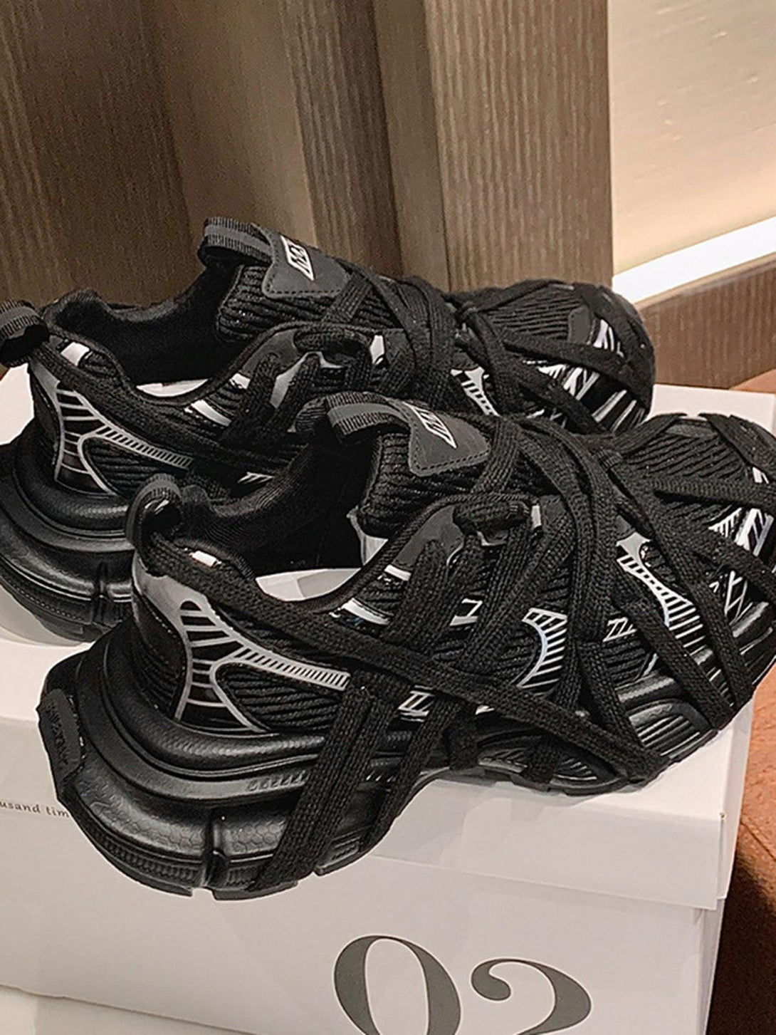 Black lace-up sneakers by TALISHKO, highlighting intricate design details for a casual look.