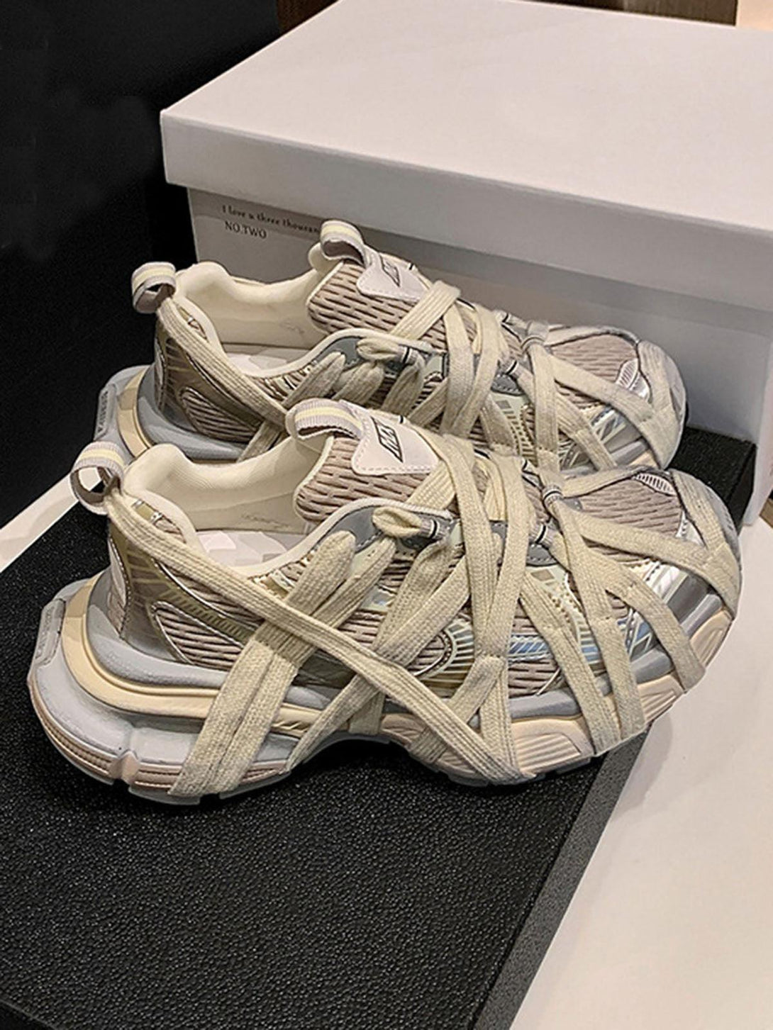 TALISHKO high street sneakers with intricate beige lace-up design on display for a chic look.
