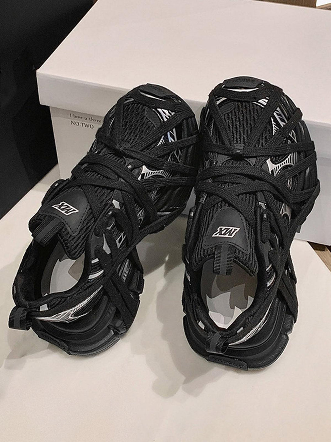 Intricate black lace-up design on TALISHKO sneakers, perfect for a high street casual vibe.