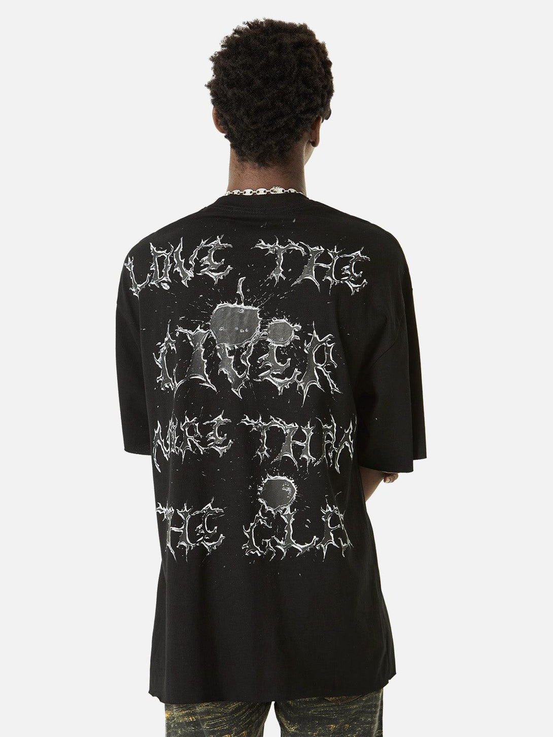 Model wearing black TALISHKO T-shirt with bold lettering design on the back.