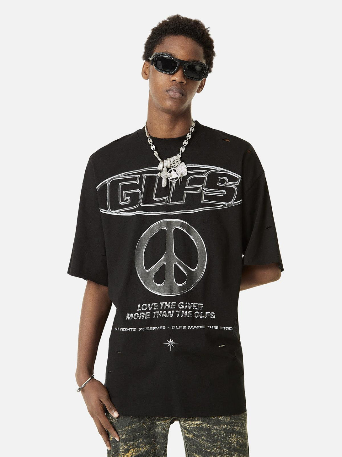 Model wearing black short-sleeved T-shirt by TALISHKO with bold peace symbol and lettering.
