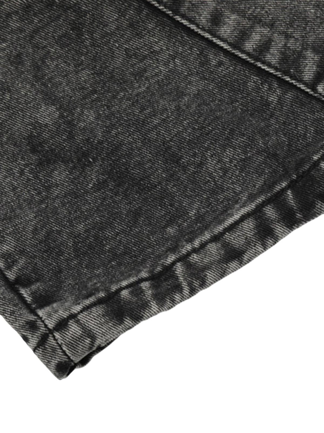 A tight crop highlighting TALISHKO's dark wash trousers, showcasing texture and stitching detail.