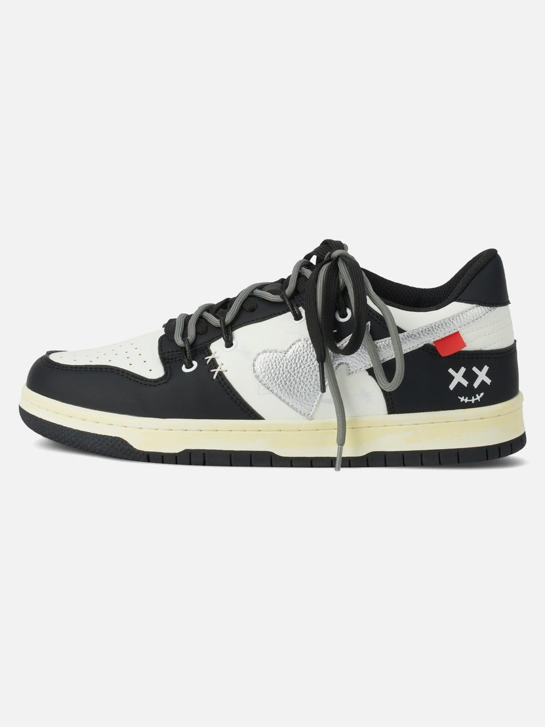 Side view of TALISHKO high street sneakers in black and white with heart and cross details.