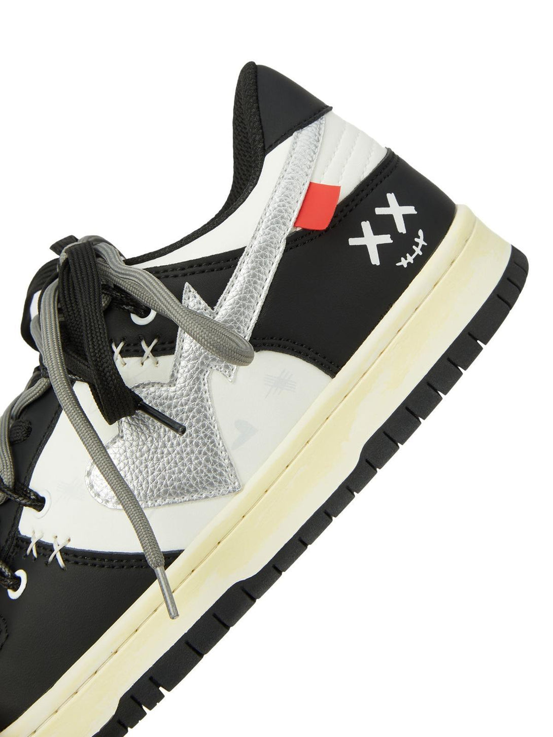 Side view of TALISHKO sneakers showcasing black and white design with unique "XX" detail.