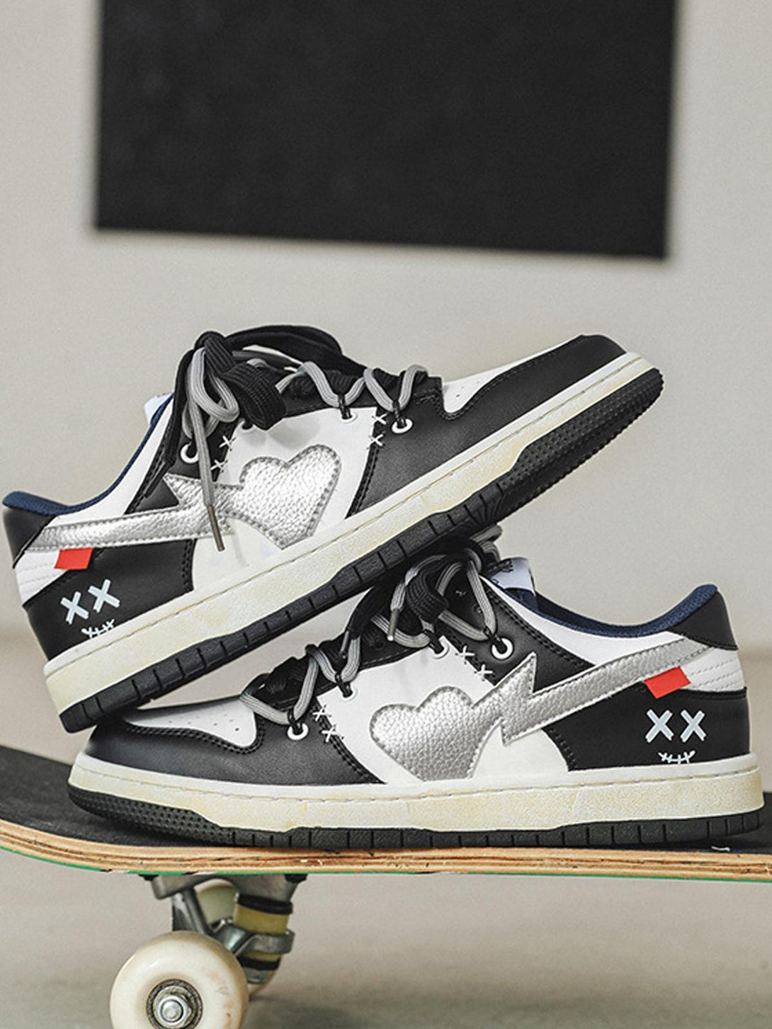 TALISHKO sneakers with heart and cross details, styled on a skateboard for urban flair.